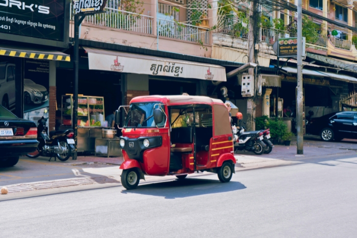 Tuk tuk driving through busy Cambodian street