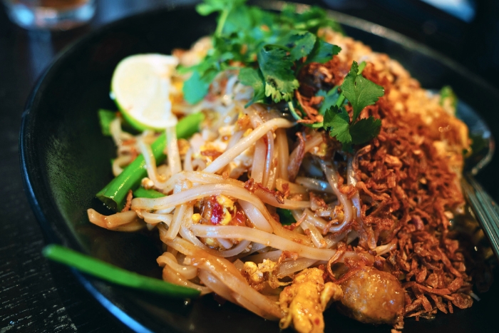 Enjoying Pad Thai during a trip to Thailand