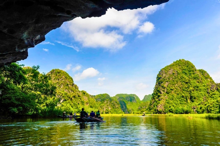 Boat ride in Tam Coc between rice fields and cliffs during a small-group trip to Vietnam