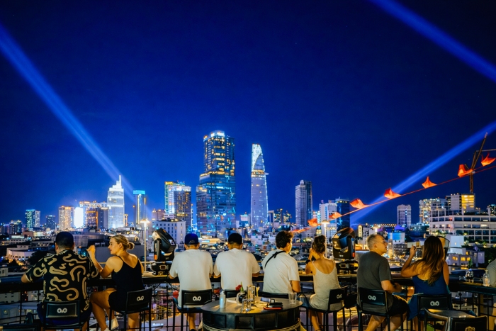 Rooftop break facing the illuminated city during a 48-hour Saigon itinerary