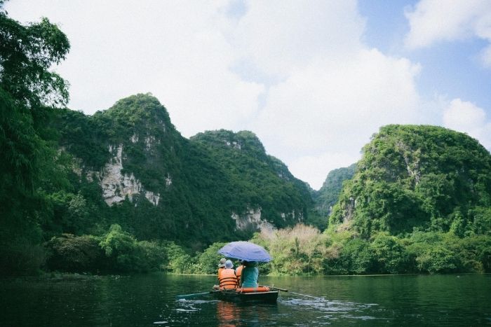 A boat tour in Trang An takes visitors through caves, valleys, and hidden temples